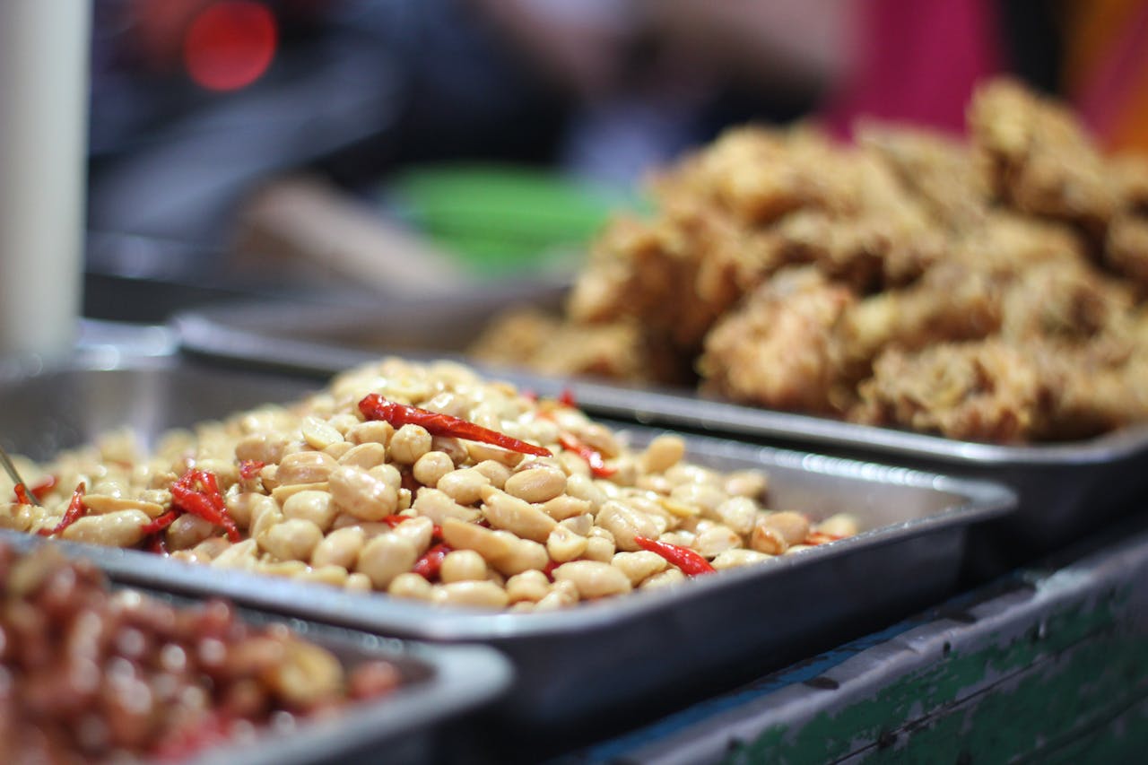 gallery-5 Close-up of a spicy peanut mix and fried snacks on a stainless steel tray, ideal for street food themes.