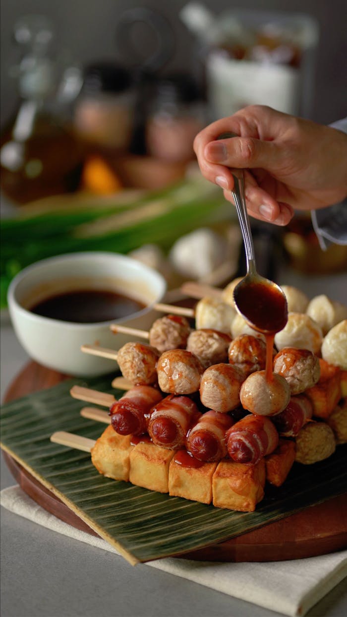 hero-img-01 Skewered sausage and meatballs with savory sauce, perfect for appetizer platters.