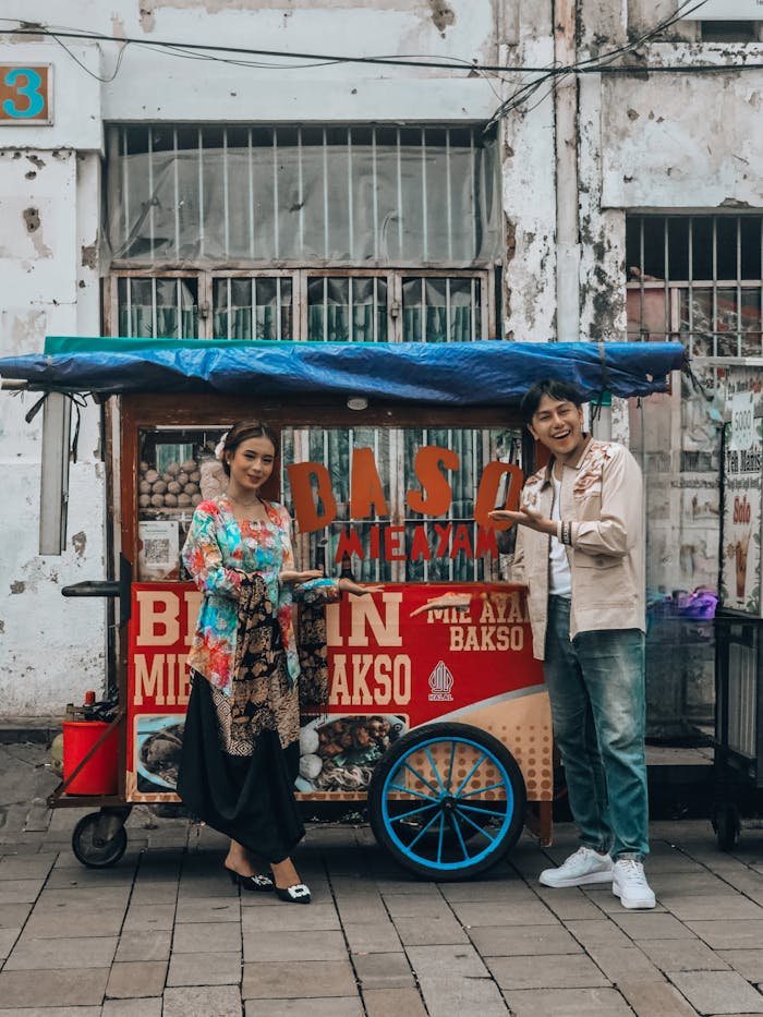 gallery-3 Indonesian street food cart with two happy adults enjoying bakso in Jakarta, Indonesia.