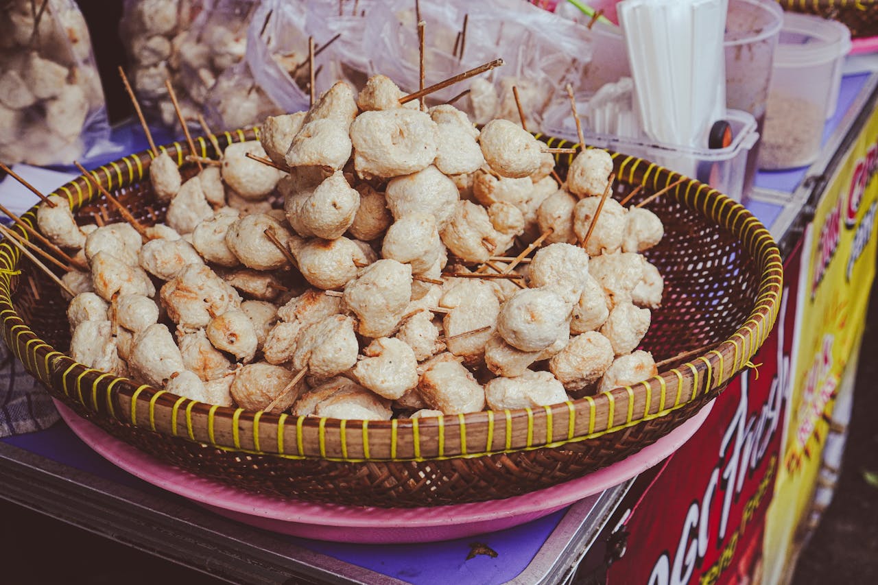gallery-1 Appetizing skewered street food displayed in a traditional basket at an outdoor market.
