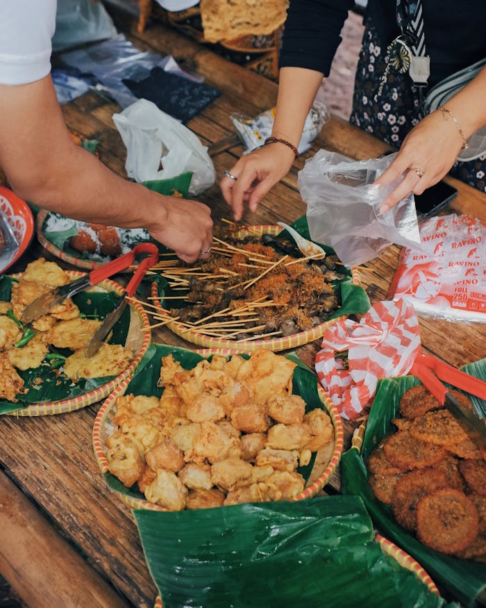 services-03 Close-up of traditional Indonesian street food stalls in Bandung with locals selecting snacks.